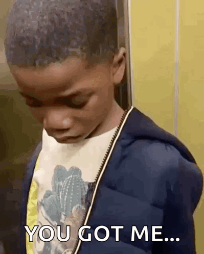 A Young Boy Is Standing Next To A Yellow Wall And Says `` You Got Me '' . GIF