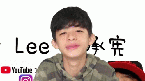 a young boy stands in front of a sign that says lee