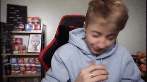 A Young Boy Wearing A Blue Hoodie And A Red Chair GIF