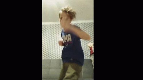 A Young Boy Wearing A Blue T-Shirt With The Word Tmf On It Is Dancing On A Couch . GIF