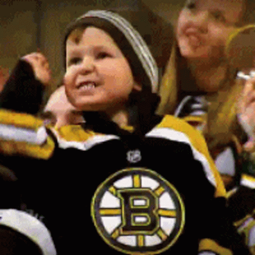 A Young Boy Wearing A Boston Bruins Jersey Is Cheering GIF