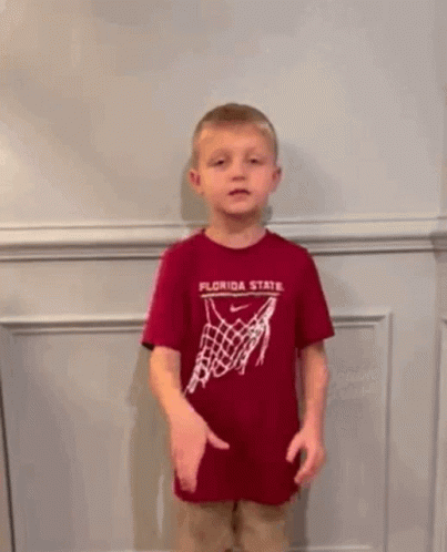 a young boy wearing a crown and a shirt that says go noles