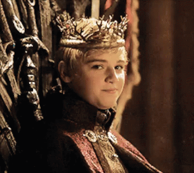 A Young Boy Wearing A Crown Sits On A Throne GIF