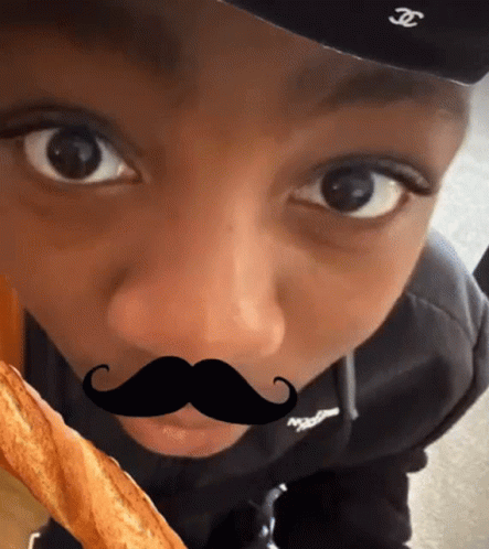 A Young Boy Wearing A Hat And A Fake Mustache GIF