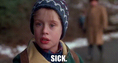 A Young Boy Wearing A Hat And A Jacket Is Standing On A Sidewalk And Says `` Sick '' . GIF