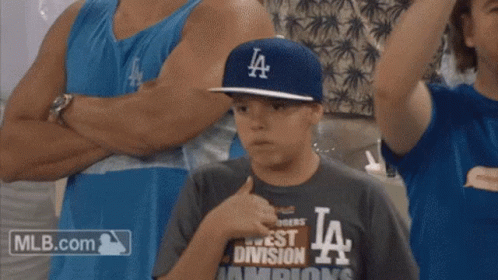 A Young Boy Wearing A La Hat And A Mlb.com Shirt GIF