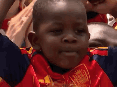 A Young Boy Wearing A Red And Blue Jersey With A Shield On It GIF