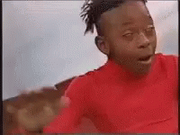 A Young Boy Wearing A Red Shirt Is Making A Funny Face . GIF