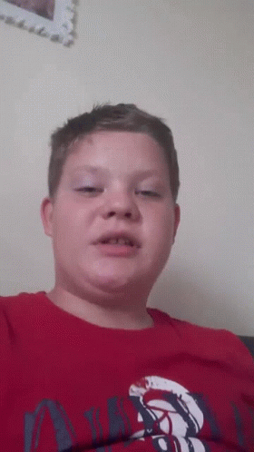 A Young Boy Wearing A Red Shirt That Says ' Abercrombie & Fitch ' On It GIF