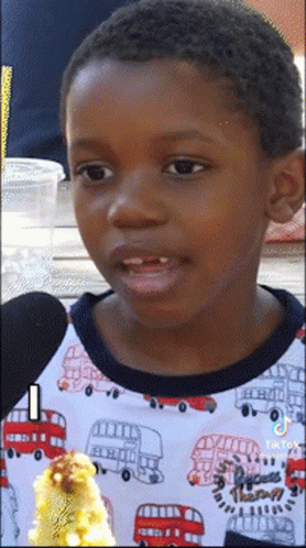 A Young Boy Wearing A Shirt With A Double Decker Bus On It GIF