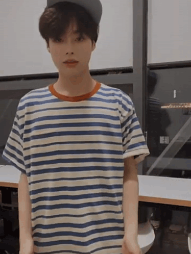 A Young Boy Wearing A Striped Shirt And A Hat GIF