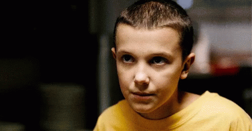 A Young Boy Wearing A Yellow T-Shirt Is Looking At The Camera . GIF