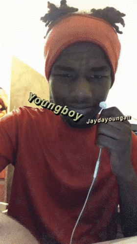 A Young Boy Wearing An Orange Headband Is Holding A Pair Of Earbuds GIF
