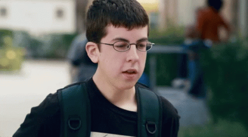 A Young Boy Wearing Glasses And A Black Shirt GIF