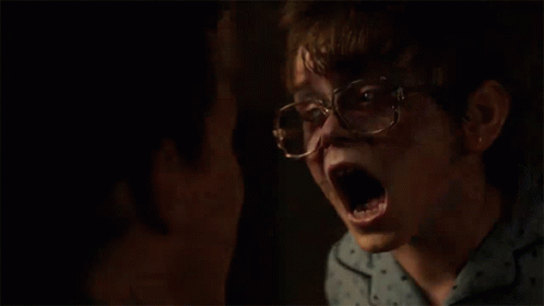 A Young Boy Wearing Glasses And A Blue Shirt Is Looking At Another Boy . GIF