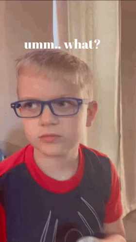 A Young Boy Wearing Glasses And A Spiderman Shirt Is Making A Funny Face And Asking What . GIF