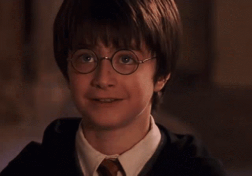 A Young Boy Wearing Glasses And A Tie Smiles GIF