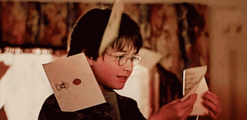 a young boy wearing glasses is reading a letter