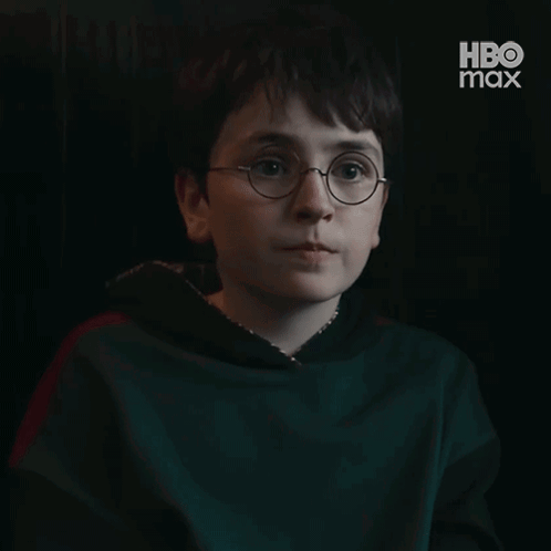 A Young Boy Wearing Glasses Is Smiling In A Dark Room With Hbo Max Written On The Bottom GIF