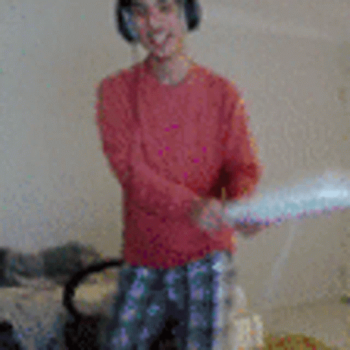 a young boy wearing headphones is holding a pillow in his hands