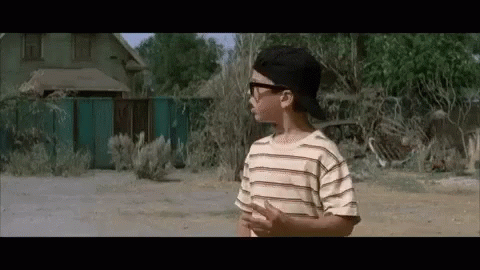 A Young Boy Wearing Sunglasses And A Baseball Cap GIF