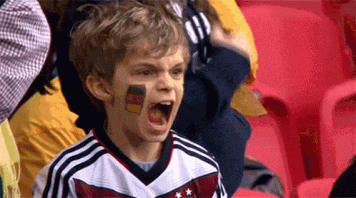 A Young Boy With A German Flag Painted On His Face Is Screaming GIF