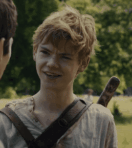 A Young Boy With A Sword On His Back Is Smiling And Talking To Another Person GIF