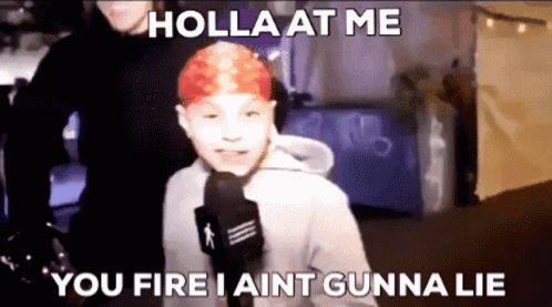 A Young Boy With Red Hair Is Talking Into A Microphone . GIF