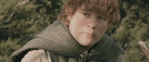 A Young Boy With Red Hair Is Wearing A Gray Vest And A Green Scarf . GIF
