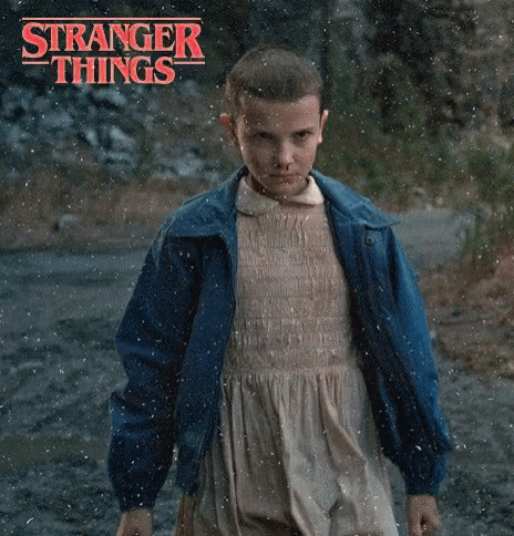 A Young Girl In A Dress And Blue Jacket Is Standing In The Rain . GIF