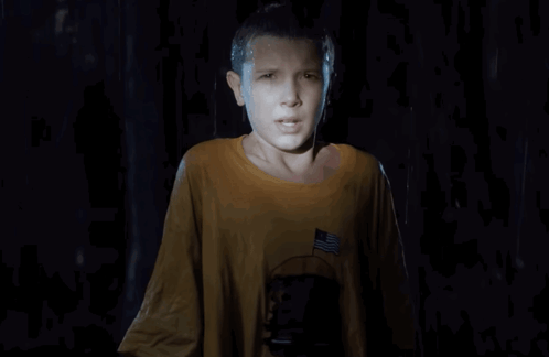 A Young Girl In A Yellow Shirt With An American Flag On The Pocket GIF