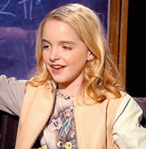 A Young Girl Is Smiling In Front Of A Blackboard With The Number 2 On It GIF