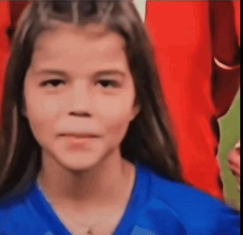 A Young Girl Wearing A Blue Shirt Is Smiling For The Camera GIF