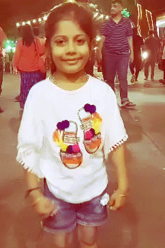 A Young Girl Wearing A White Shirt With A Picture Of Shoes On It GIF