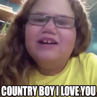 a young girl wearing glasses and a yellow shirt says country boy i love you .