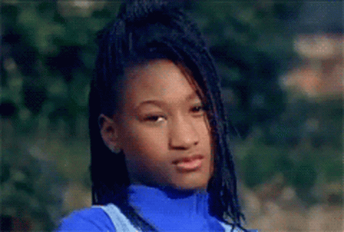 A Young Girl With Dreadlocks Is Wearing A Blue Turtleneck And Overalls GIF