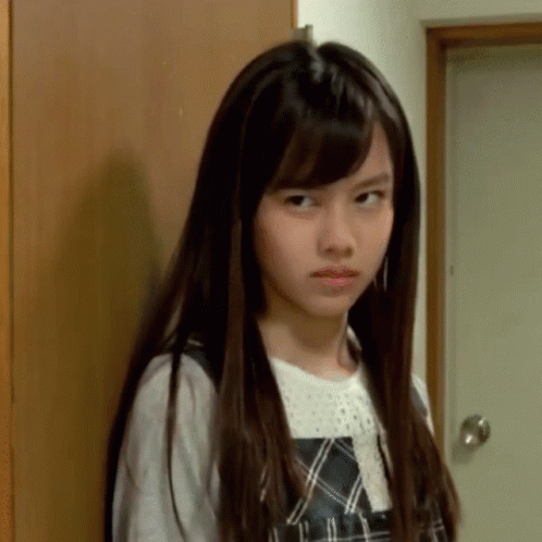 A Young Girl With Long Hair Is Making A Funny Face GIF