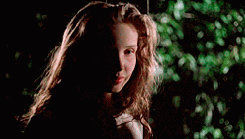 A Young Girl With Long Hair Is Sitting On A Swing In The Dark . GIF