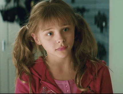 A Young Girl With Pigtails Is Wearing A Pink Shirt And A Red Jacket GIF