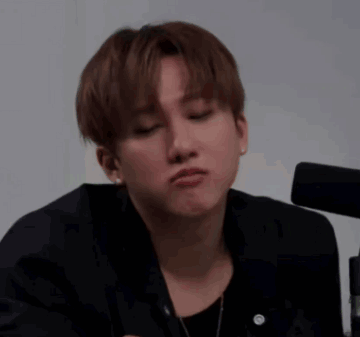 A Young Man In A Black Jacket Is Making A Funny Face With His Eyes Closed . GIF