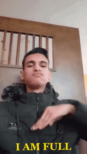 A Young Man In A Black Jacket Says I Am Full In Yellow Letters GIF