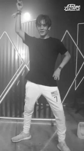 A Young Man In A Black Shirt And White Sweatpants With The Number 7 On The Side GIF