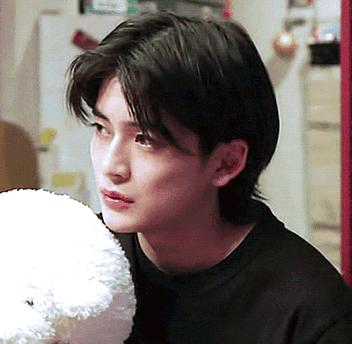 A Young Man In A Black Shirt Holds A Stuffed Animal GIF
