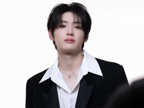 A Young Man In A Black Suit And White Shirt GIF