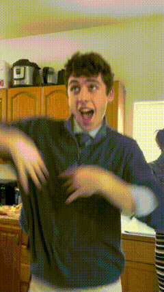 A Young Man In A Blue Shirt And Tie Is Dancing In A Kitchen GIF