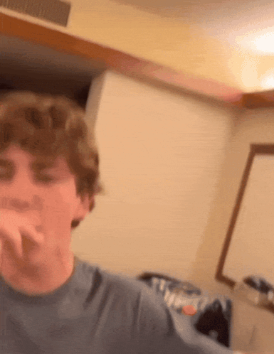 A Young Man In A Blue Shirt Is Making A Face GIF