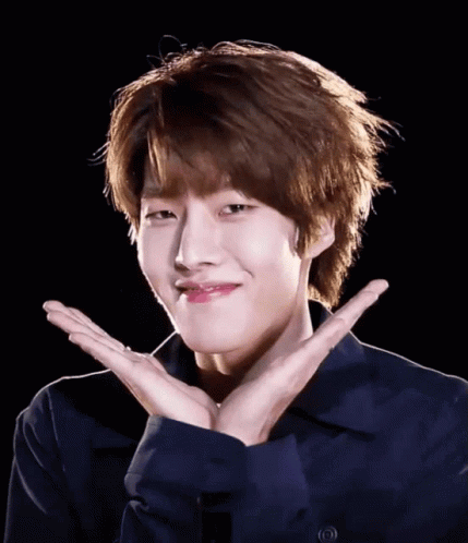 A Young Man In A Blue Shirt Is Making A Face With His Hands GIF