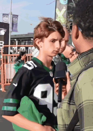 A Young Man In A Jets Jersey Is Being Interviewed By A Man Holding A Microphone GIF