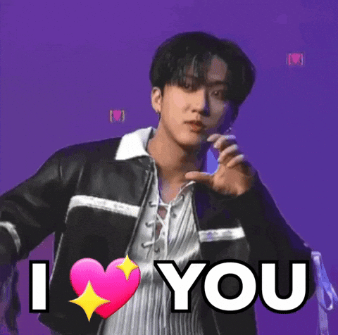 A Young Man In A Leather Jacket Is Holding A Pink Heart And Says `` I Love You '' . GIF
