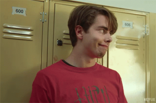 A Young Man In A Red Shirt Is Standing In Front Of Lockers With The Number 600 On Them GIF